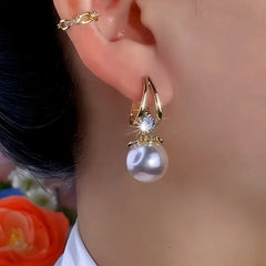 Model showcasing the dangle and style of the 14K Gold-Plated Exquisite Pearl Earrings