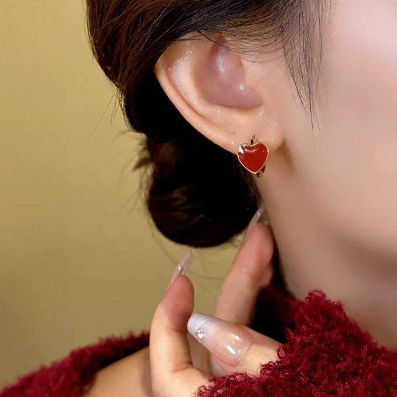 Model showcasing the dangle and style of the 14K Gold-Plated Exquisite Simple Red Heart Hoop Earrings