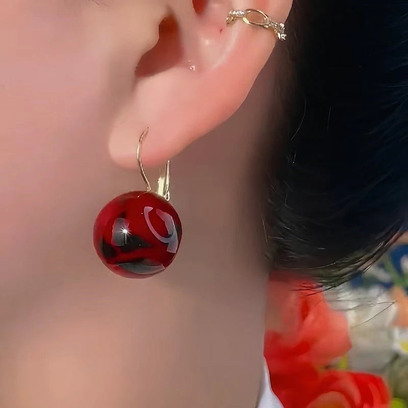 Close-up detail of the sparkling zircons and plating on the Red Ball Earrings