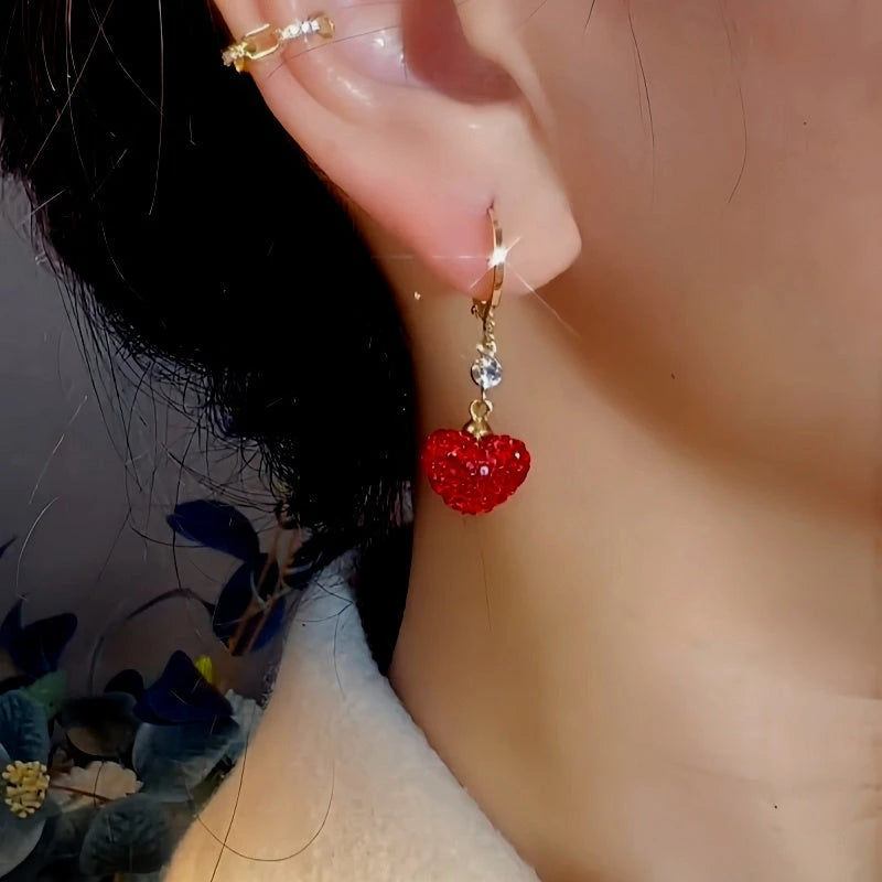 Model showcasing the dangle and style of the 14K Gold-Plated Exquisite Zircon Red Heart Earrings