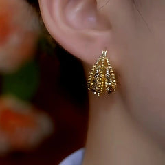 Model showcasing the dangle and style of the 14K Gold-Plated Firework Tassel Bead Earrings