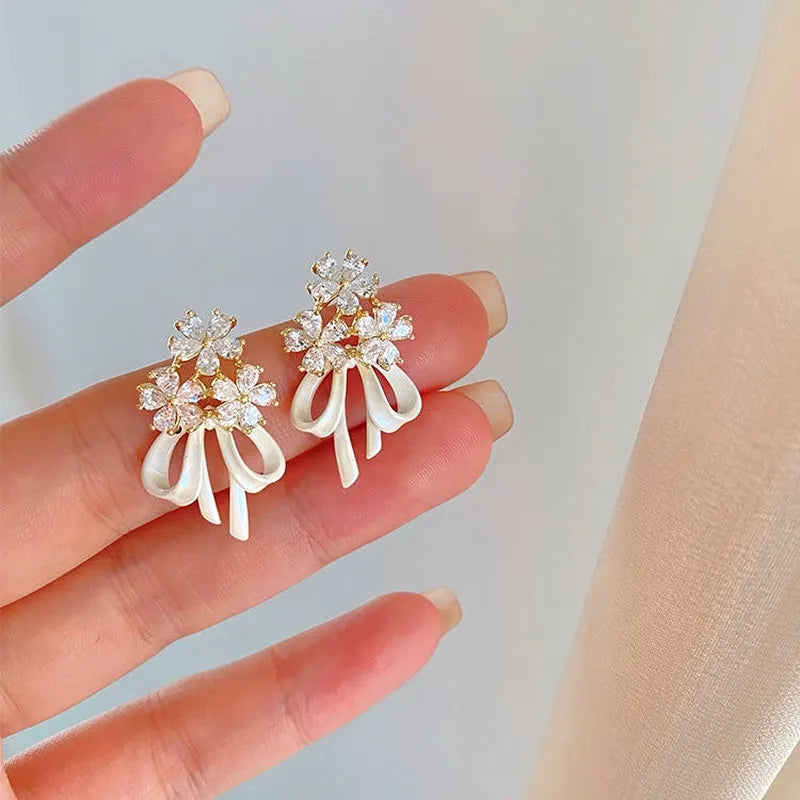 Angled view of the 14K Gold-Plated Flower Bow Ribbon Earrings