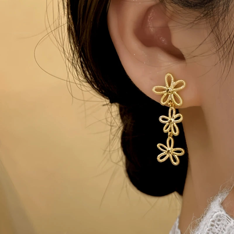 Model showcasing the dangle and style of the 14K Gold-Plated Flower Knot Tassel Earrings