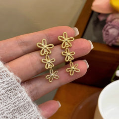 Angled view of the 14K Gold-Plated Flower Knot Tassel Earrings