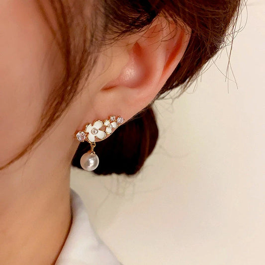 Model showcasing the dangle and style of the 14K Gold-Plated Flower Pearl Earrings