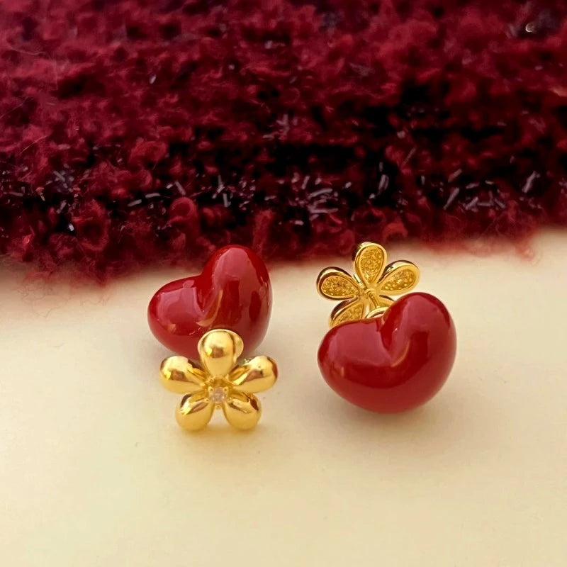 Model showcasing the dangle and style of the 14K Gold-Plated Flower Red Heart Bead Jacket Earrings