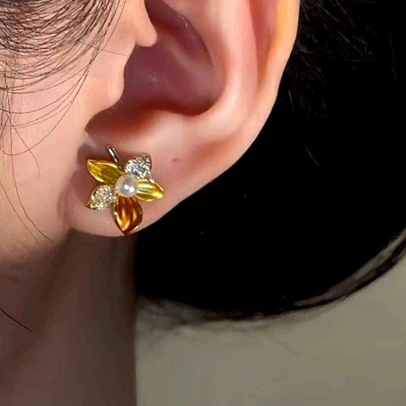 Model showcasing the dangle and style of the 14K Gold-Plated Flower Stud Earrings
