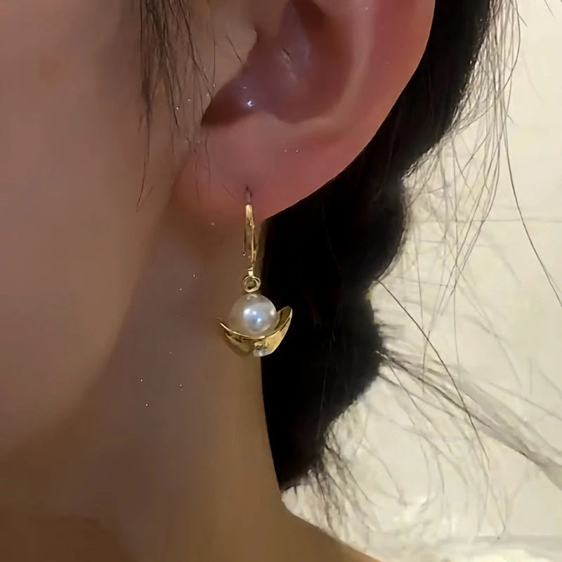 Model showcasing the dangle and style of the 14K Gold-Plated Fortune-Bringing Pearl Ingot Earrings