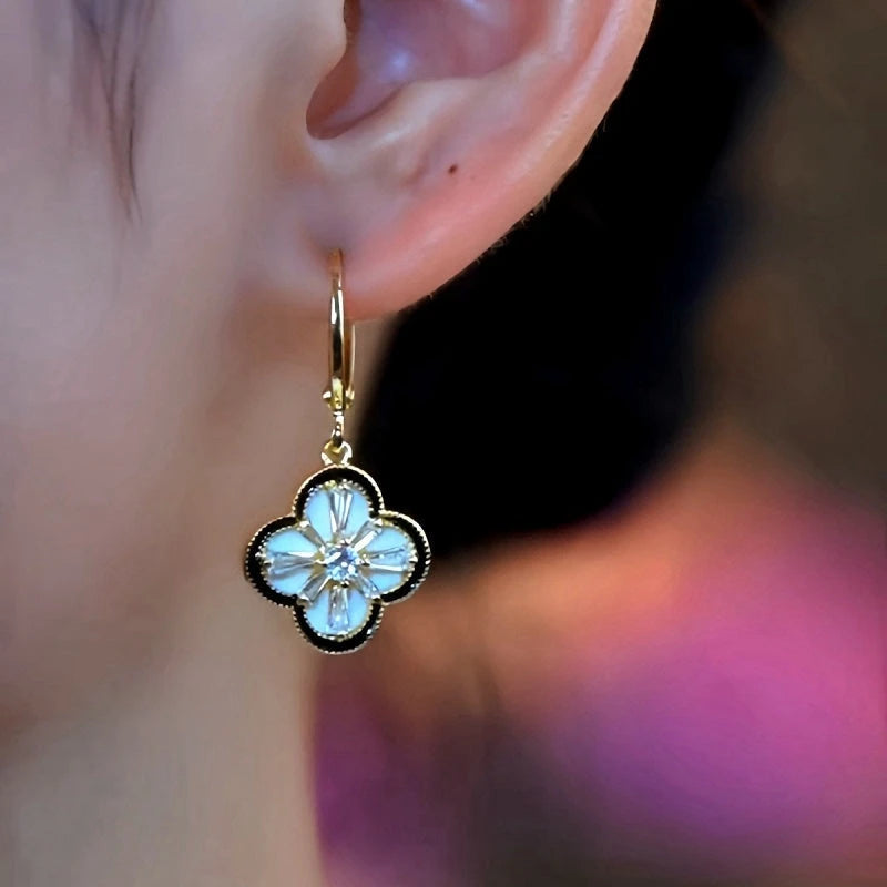 Model showcasing the dangle and style of the 14K Gold-Plated Four-Leaf Clover Earrings