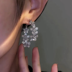 Model showcasing the dangle and style of the 14K Gold-Plated Front And Back Zircon Flower Earrings