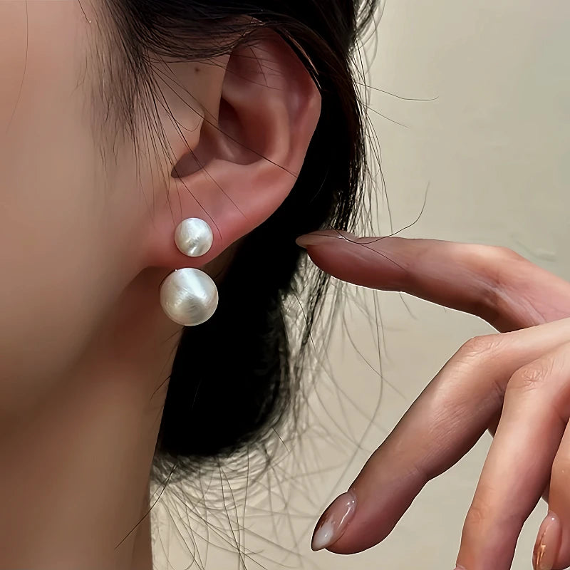 Model showcasing the dangle and style of the 14K Gold-Plated Frosted Brushed Front And Back Ball Earrings