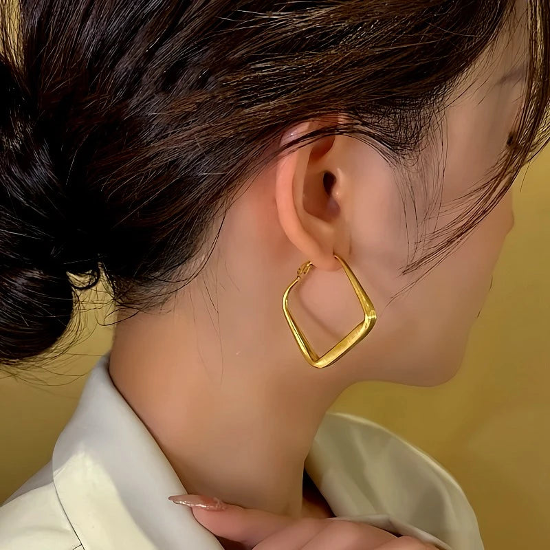 Model showcasing the dangle and style of the 14K Gold-Plated Geometric Square Earrings