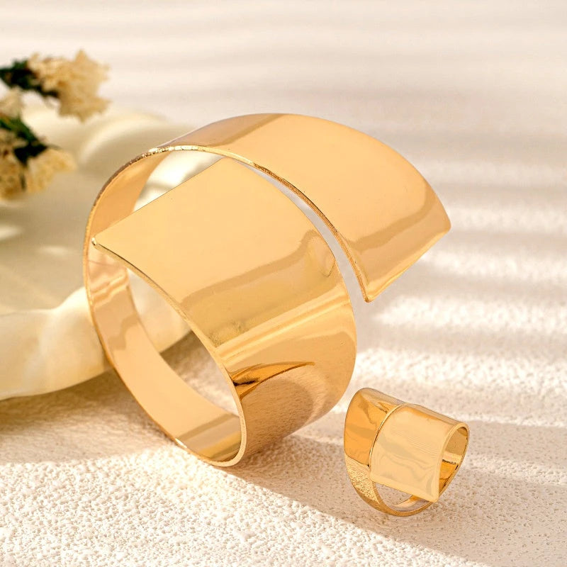 Model wearing the 14K Gold-Plated Geometric Wide Open Bracelet And Ring Set to highlight its design on the wrist