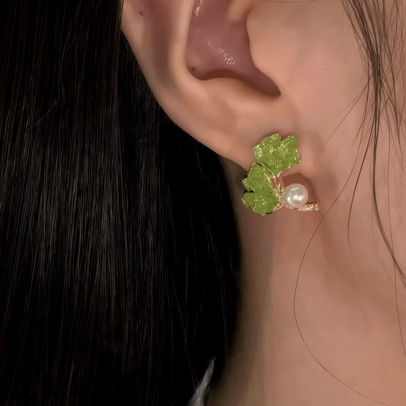 Model showcasing the dangle and style of the 14K Gold-Plated Ginkgo Leaf Pearl Earrings