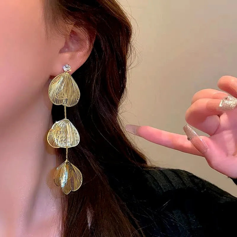 Model showcasing the dangle and style of the 14K Gold-Plated Ginkgo Leaf Tassel Earrings