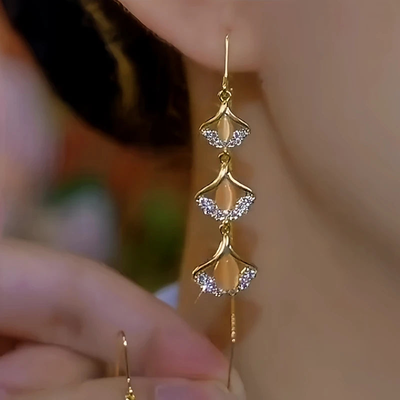 Model showcasing the dangle and style of the 14K Gold-Plated Ginkgo Leaf Tassel Threader Earrings