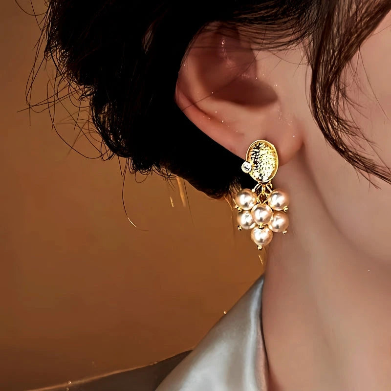 Model showcasing the dangle and style of the 14K Gold-Plated Grapes Pearl Tassel Earrings