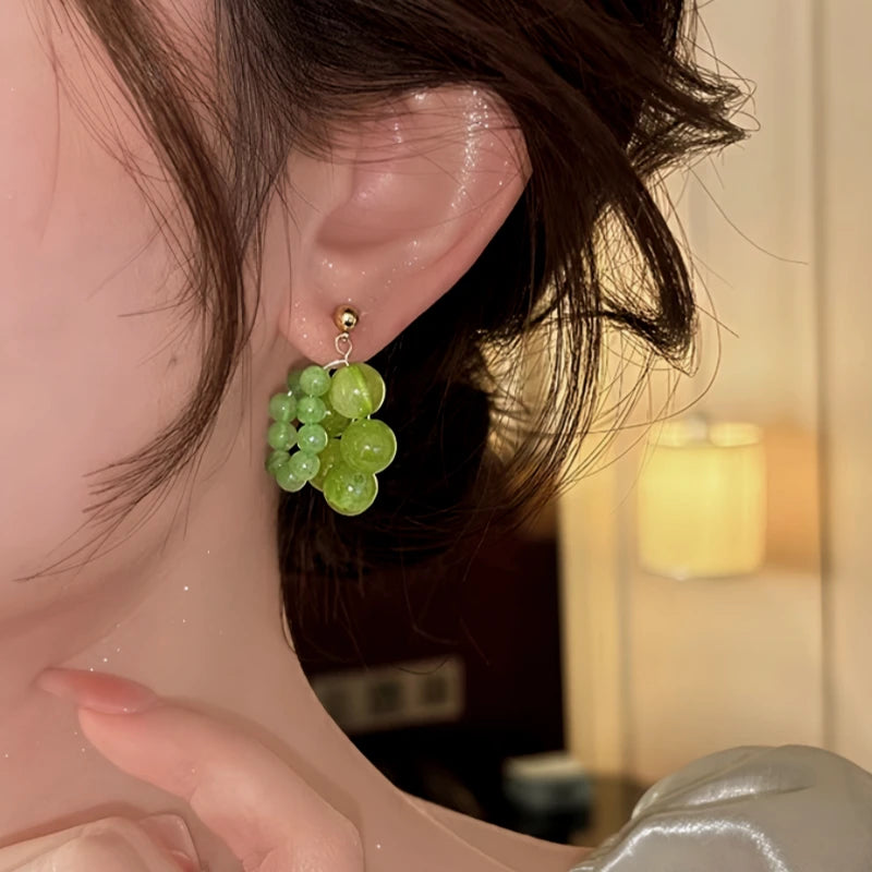 Model showcasing the dangle and style of the 14K Gold-Plated Green Bead Earrings