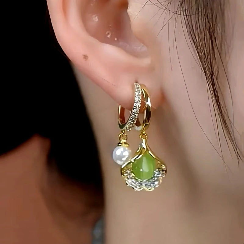 Model showcasing the dangle and style of the 14K Gold-Plated Green Crystal Ginkgo Leaf Earrings