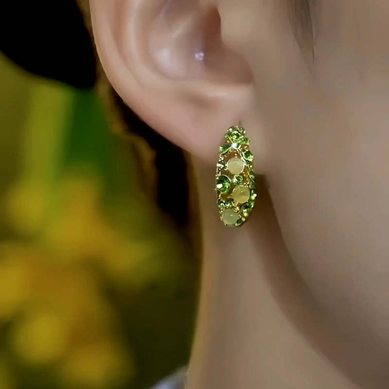 Model showcasing the dangle and style of the 14K Gold-Plated Green Diamond Cat's Eye Stone Little Hoop Earrings