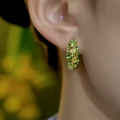 Model showcasing the dangle and style of the 14K Gold-Plated Green Diamond Cat's Eye Stone Little Hoop Earrings