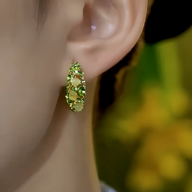 Close-up detail of the sparkling zircons and plating on the Cat's Eye Huggie Hoops