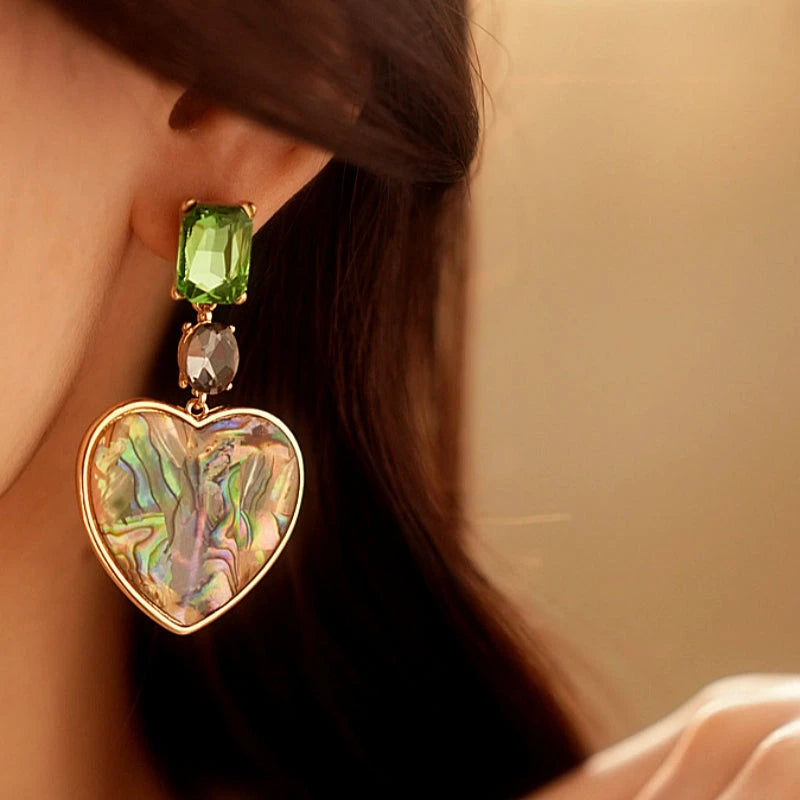 Angled view of the 14K Gold-Plated Green Diamond Heart Earrings