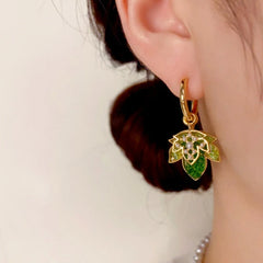 Model showcasing the dangle and style of the 14K Gold-Plated Green Double-Layer Maple Leaf Earrings