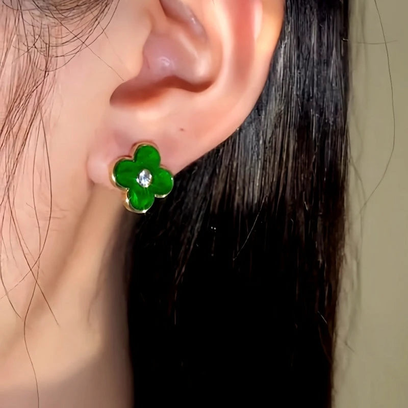 Model showcasing the dangle and style of the 14K Gold-Plated Green Four-Leaf Stud Earrings