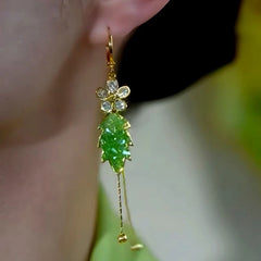 Model showcasing the dangle and style of the 14K Gold-Plated Green Gradient Crystal Leaf Flower Earrings