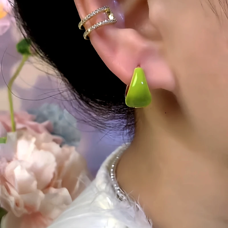 Model showcasing the dangle and style of the 14K Gold-Plated Green Oil Water Drop Earrings