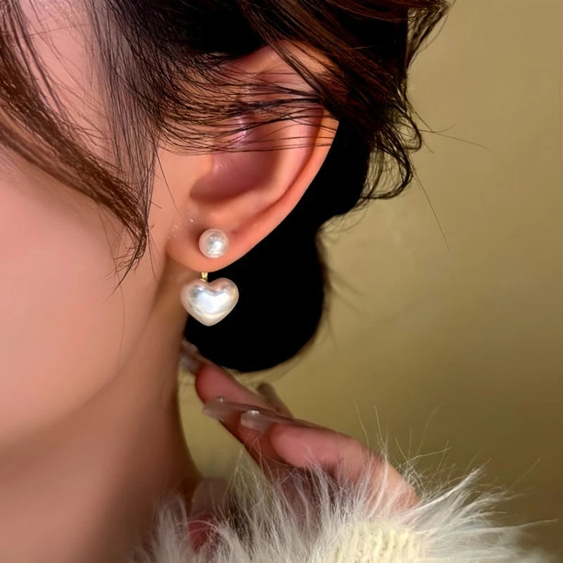 Model showcasing the dangle and style of the 14K Gold-Plated Heart Bead Earrings