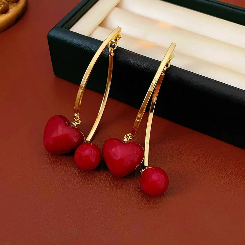 Model showcasing the dangle and style of the 14K Gold-Plated Heart Pearl Tassel Earrings