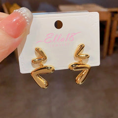 Angled view of the 14K Gold-Plated Heart Tassel Earrings