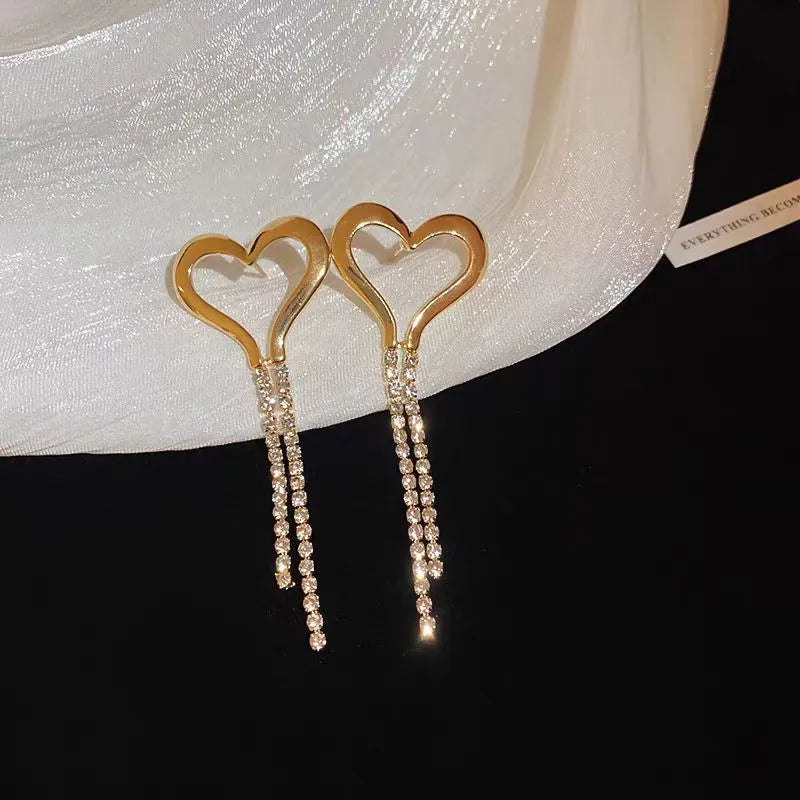 Model showcasing the dangle and style of the 14K Gold-Plated Heart Zircon Tassel Earrings