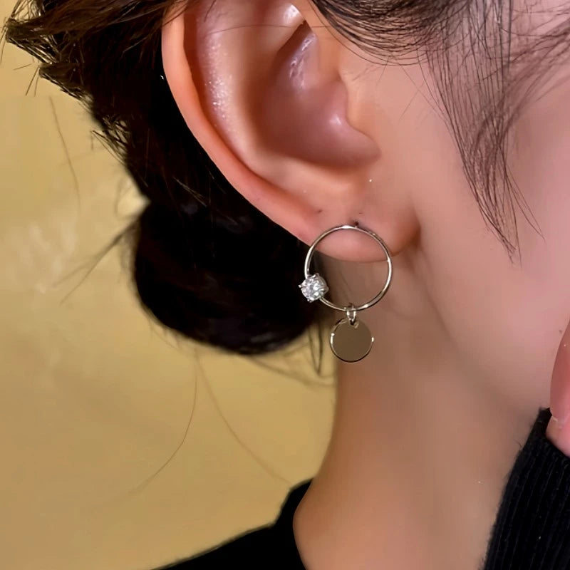 Model showcasing the dangle and style of the 14K Gold-Plated Hollow Diamond Hoop Earrings