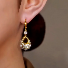 Model showcasing the dangle and style of the 14K Gold-Plated Hollow Diamond Water Drop Earrings