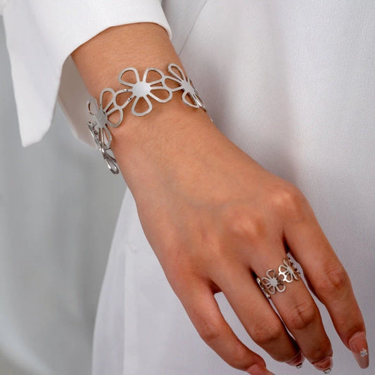 Model wearing the 14K Gold-Plated Hollow Flower Bracelet And Rings to highlight its design on the wrist