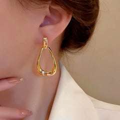 Model showcasing the dangle and style of the 14K Gold-Plated Hollow Water Drop Earrings