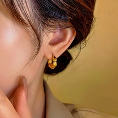 Model showcasing the dangle and style of the 14K Gold-Plated Hoop Earrings