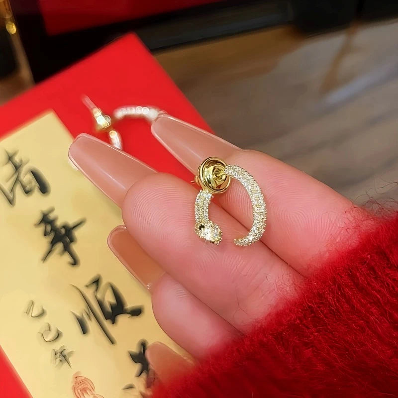 Angled view of the 14K Gold-Plated Interlaced Snake Head And Tail Earrings