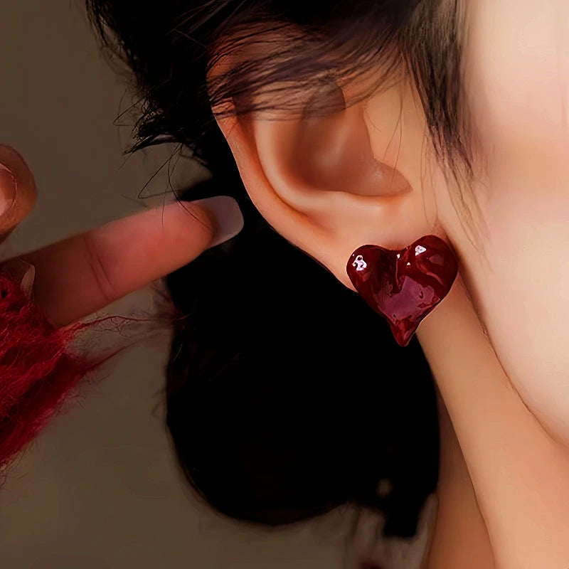 Model showcasing the dangle and style of the 14K Gold-Plated Irregular Heart Stud Earrings