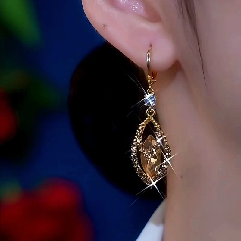 Model showcasing the dangle and style of the 14K Gold-Plated Jade Leave Brown Crystal Zircon Earrings