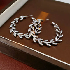 Model showcasing the dangle and style of the 14K Gold-Plated Leaf C-Shaped Hoop Earrings