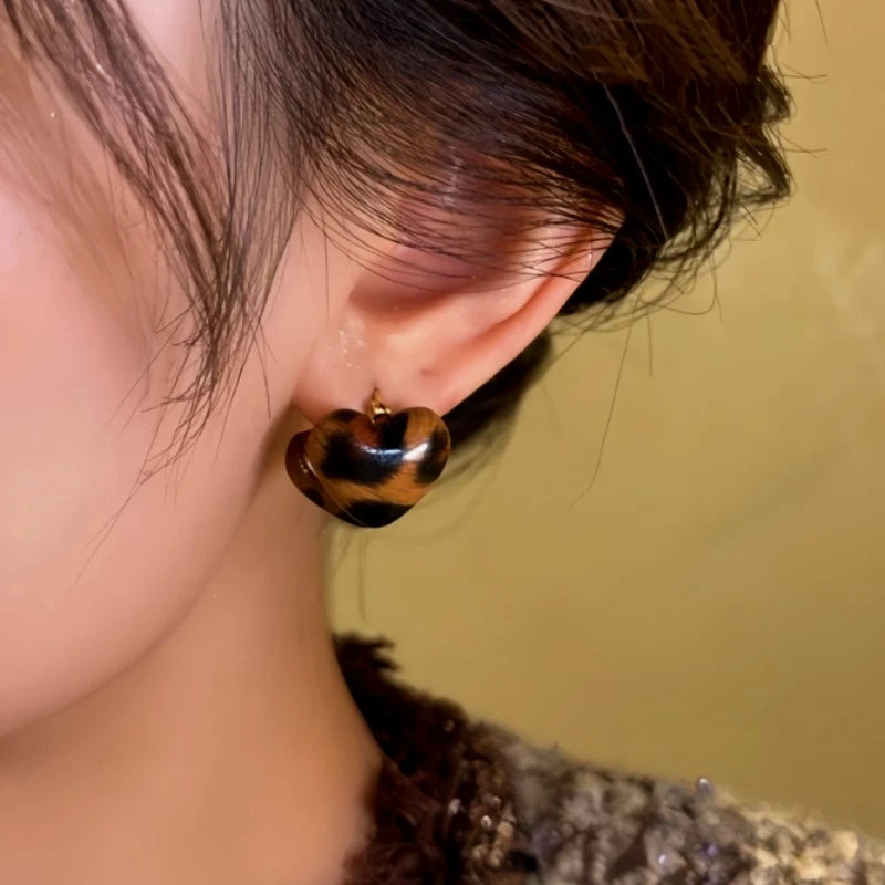 Model showcasing the dangle and style of the 14K Gold-Plated Leopard Heart Earrings