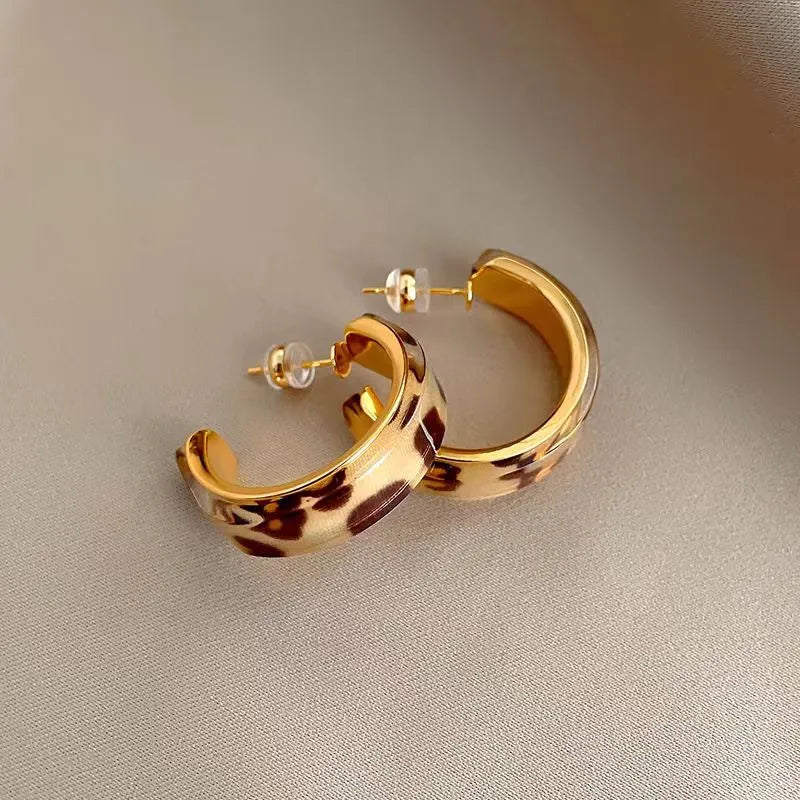 Model showcasing the dangle and style of the 14K Gold-Plated Leopard Print C-Shaped Earrings