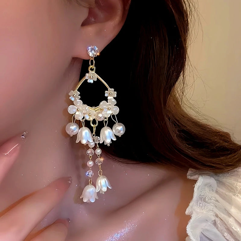 Model showcasing the dangle and style of the 14K Gold-Plated Lily Of The Valley Pearl Tassel Earrings