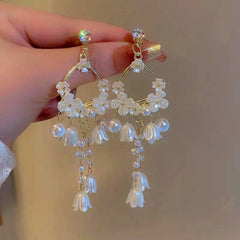 Angled view of the 14K Gold-Plated Lily Of The Valley Pearl Tassel Earrings