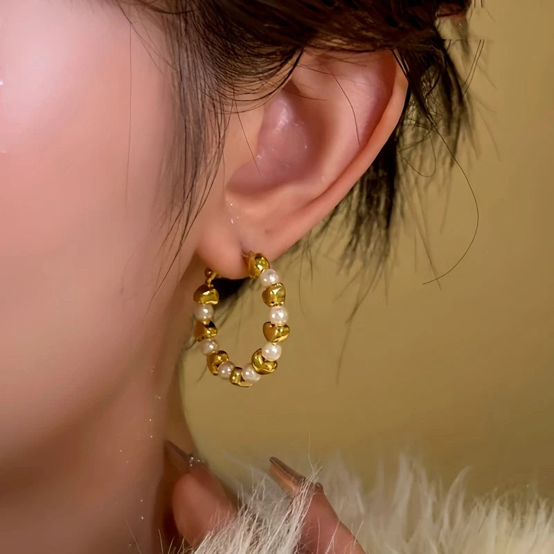 Model showcasing the dangle and style of the 14K Gold-Plated Love Bead Hoop Earrings