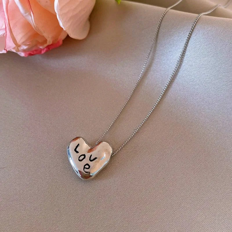 Close-up of the pendant and clasp on the Love Script Necklace